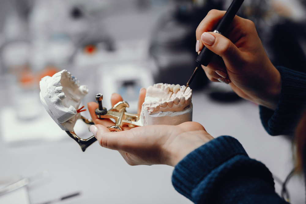 Dentist showing full mouth implant model to elderly patient – Denver Dental Implants.