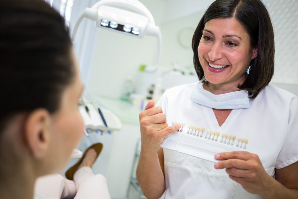 Dentist showing veneer shade options to patient during cosmetic dentistry consultation in Denver.