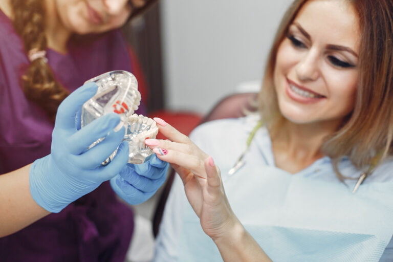 Dentist handing aligners during an Invisalign in Denver appointment.