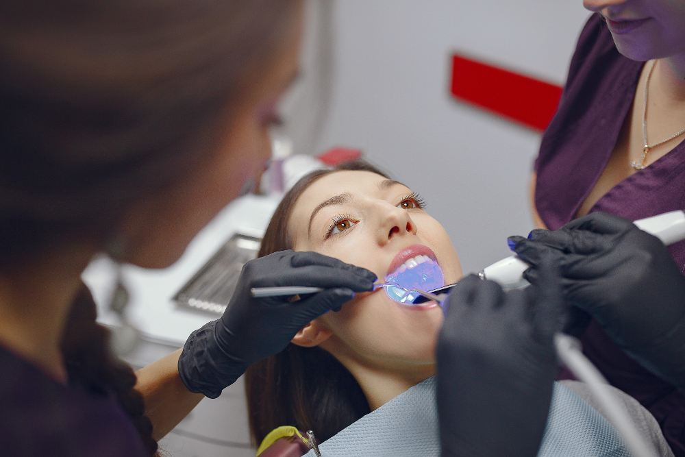 Dentist applying whitening solution during professional KoR teeth whitening Denver procedure.