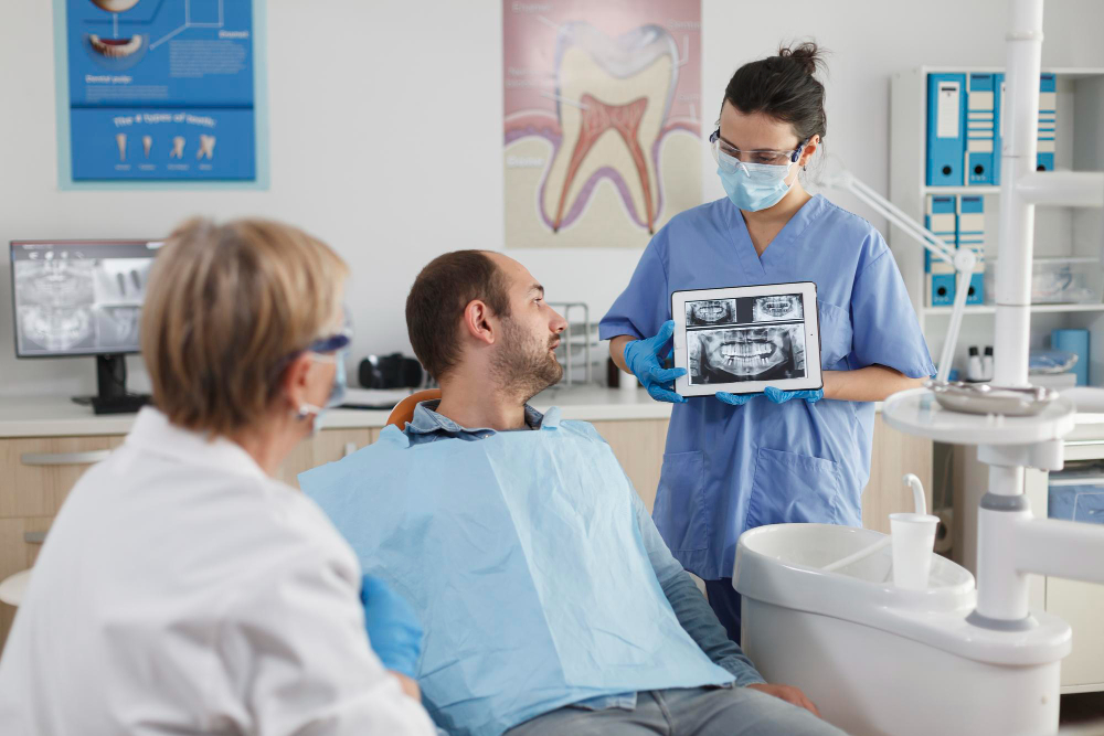 Dentist reviewing X-rays with patient as part of Preventive Dentistry planning.